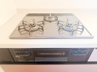 三口コンロが備わったキッチンで調理の際の使い勝手に配慮されています。シンプルなデザインでお手入れがしやすい構造です。調理スペースも確保されており様々な料理に対応できます。
