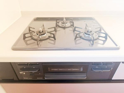 三口コンロが備わったキッチンで調理の際の使い勝手に配慮されています。シンプルなデザインでお手入れがしやすい構造です。調理スペースも確保されており様々な料理に対応できます。