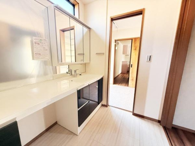 明るい日差しが差し込む洗面台エリアです。収納スペースが豊富ですっきりとした印象を与えます。広々としたカウンターが使いやすさを高めています。鏡付きのキャビネットもあり日々の身支度が快適に行えます。