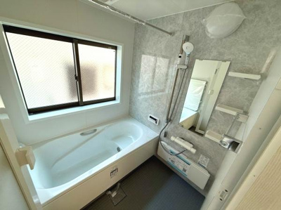 窓付きで明るいバスルームです。使いやすいシャワー設備が整っています。浴槽は広々とした設計になっています。お手入れがしやすい壁材を使用しています。収納棚も充実しています。