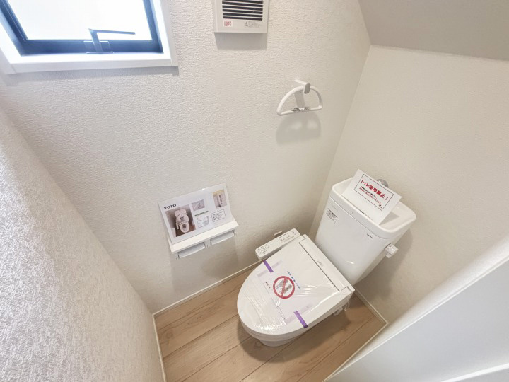 手洗い付のロータンクモデルを採用し、省スペースながら機能的。タオルリングや2連式のペーパーホルダーが設置されているのも嬉しいポイント。階段下スペースを有効活用した配置で居住空間の効率性を高めています。