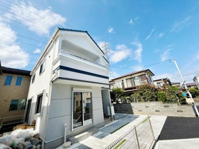 ２号棟。爽やかな青空の下に建つ外観が印象的な住宅です。広々とした駐車スペースが確保されており車の出し入れもスムーズに行えます。周囲との調和が取れた落ち着いた環境が魅力です。