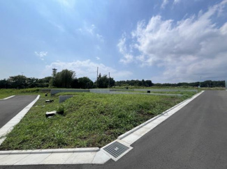 広々とした敷地が広がり前面道路も整っています。周辺は自然が多く開放感があります。道路はアスファルト舗装されており車の出入りもしやすい環境です。現地の様子がよく分かる一枚です。