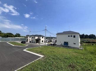 広々とした敷地が特徴的な現地土地写真です。周囲には新しい住宅が立ち並び明るく開放感があります。道路も整備されており車でのアクセスもしやすい環境です。自然を感じられる眺めも魅力の一つです。