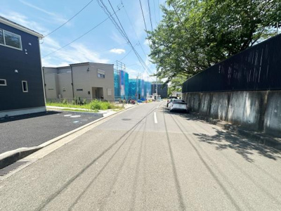 現地の前面道路は車通りが少なく落ち着いた雰囲気です。日当たりがしっかりとあり明るい印象を受けます。周囲には新しい建物も建設中で街並みの変化が感じられます。道路幅も比較的広くすれ違いも安心です。