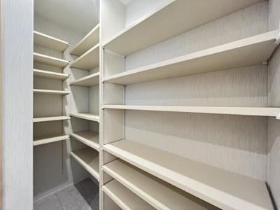 壁一面の棚が備え付けられた収納スペースです。奥行きがあり様々な物をすっきり整理できます。高さの異なる棚で使い分けがしやすい設計です。空間を有効活用できるのが魅力です。