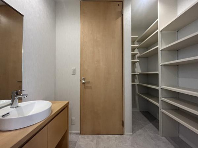 白を基調とした内装が明るい印象を与えます。収納スペースが豊富に設けられており整理がしやすい洗面所です。シンプルで無駄のないデザインの洗面台が特徴的です。開放感のある空間です。