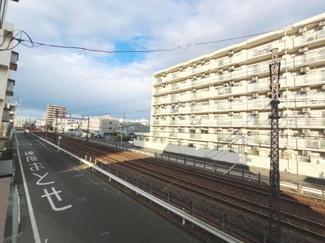 前面道路が広がる現地の様子がしっかりと確認できます。建物も整然と並んでいて周辺環境がわかりやすい写真です。空の抜け感があり開放的な印象を受けます。電車の線路も見えて交通の利便性が想像しやすいです。