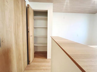 木目調の扉と床が調和された洋室です。備え付けの収納スペースがあり整理整頓もスムーズです。シンプルな内装が空間を引き立てます。明るい壁面が開放的な雰囲気を演出します。