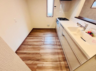 窓があり自然光が差し込む明るいキッチンです。床とシンクの色合いが調和しており清潔感が感じられます。調理スペースがすっきりとしているため動きやすい設計です。