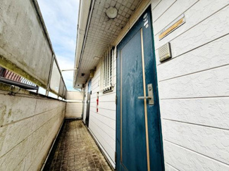 共用廊下がしっかりと確保されており落ち着いた雰囲気が特徴です。玄関扉は鮮やかな色合いで目を引きます。全体的に整理された印象を与え使い勝手のよいスペースです。建物外壁のテクスチャも魅力的です。