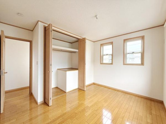 室内の収納スペースが広めに確保されています。使いやすいクローゼット扉で収納物の出し入れがしやすいです。床や建具の木目調が空間に統一感をもたらしています。二面の窓から光が入り明るい雰囲気の部屋です。