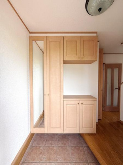 玄関には大きな収納スペースがあり整理整頓がしやすい印象です。木目調の扉が空間に温かみをプラスしています。床はタイル仕様でお手入れがしやすいです。全身鏡付きで身だしなみのチェックも便利です。