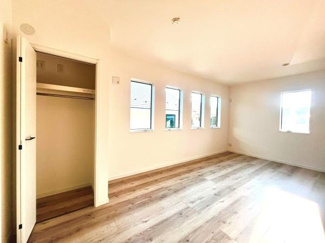 4つの窓から光が差し込む洋室です。クローゼット付きで収納も確保されています。床の風合いが落ち着いた雰囲気を感じさせます。広々とした空間でレイアウトがしやすい洋室です。明るさと機能性を兼ね備えています。