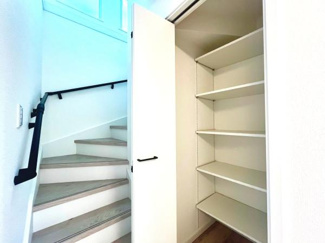 階段横に設けられた収納スペースは使いやすさを考えたシンプルな設計です。扉付きで中身を隠すことができ室内をすっきりと保ちやすいです。可動棚になっており高さ調整が可能です。