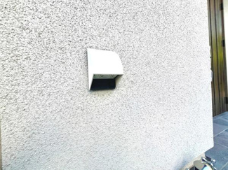 外壁に設置された換気フードが見られます。シンプルなデザインで外観に調和しています。しっかりとした設置が行われており機能性も意識されています。周囲も清潔感のある印象です。