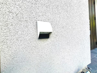 外壁に設置された換気フードが見られます。シンプルなデザインで外観に調和しています。しっかりとした設置が行われており機能性も意識されています。周囲も清潔感のある印象です。