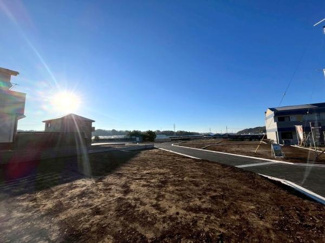 開放感のある現地土地写真です。周辺に住宅が並び落ち着いた雰囲気が感じられます。現地の状況をしっかり確認できます。陽射しがしっかり届き空の広さも印象的です。建築計画が進んでいる様子も伝わります。