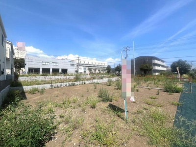 現地土地写真からは広々とした開放的な土地の様子が伺えます。周辺には住宅や施設があり日当たりも良好です。整った区画が魅力となっています。空が広がり穏やかな印象を与えます。