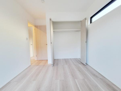 明るい色合いのフローリングが印象的な洋室です。大きなクローゼットが備わっており収納力も充分です。シンプルな内装で様々なインテリアに合わせやすい空間になっています。高窓から自然光が入るのもポイントです。