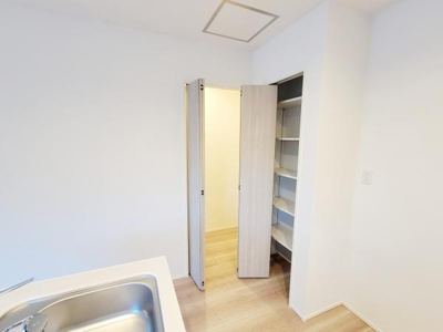 キッチン横に便利な収納スペースが備え付けられています。扉付きで見た目もすっきりと整います。棚板が複数あり整理整頓に役立ちます。収納力があり生活感を抑えられます。日常の使いやすさが感じられる収納です。