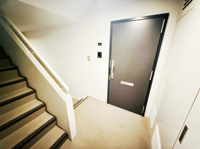 シンプルなデザインの玄関が印象的です。ドア横にはインターホンが設置されています。階段と玄関の動線もスムーズです。玄関まわりがすっきりとしていて使いやすい空間です。照明も明るく清潔感があります。