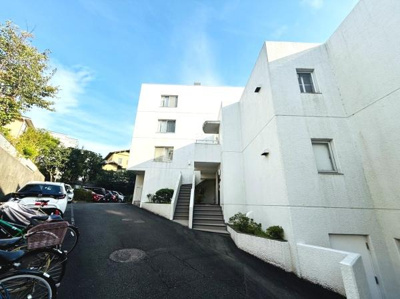 白を基調とした外観が印象的な建物です。周囲には植栽もあり清潔感があります。駐車スペースもしっかり確保されています。自転車置き場も併設されていますので多様な移動手段に対応しています。