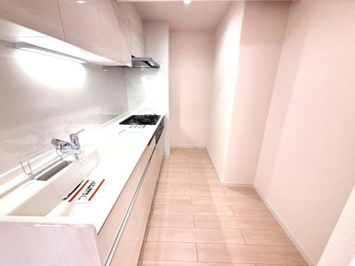 明るい色合いのフローリングと壁面が空間全体を広く感じさせます。収納も充実しておりシンクやコンロ周りもすっきりと整っています。清潔感のあるデザインで使いやすさにも配慮されています。