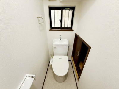 窓があることで換気がしやすくトイレ内の清潔感が保ちやすいです。壁面収納スペースも確保されており生活用品の整理が便利です。落ち着いた色合いの内装が空間に調和しています。
