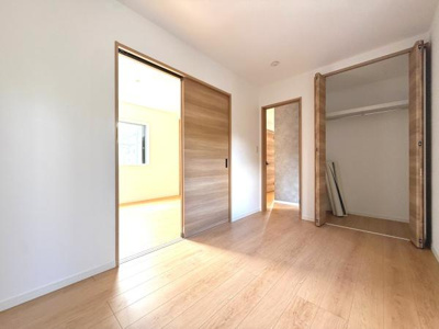 木目調の収納が空間に温かみを加えます。壁際に配置されているため動線がスムーズです。落ち着いた色合いのフロアとモダンなアクセントクロスが調和しています。