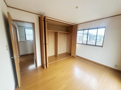 洋室はシンプルな内装で使い勝手の良さが感じられます。大きな窓からは自然光がしっかり入ります。収納スペースも充実しており整理整頓に役立ちます。床は木目がきれいで落ち着いた雰囲気です。