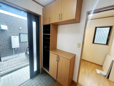 玄関には収納スペースが豊富に用意されているので整理整頓がしやすい玄関です。明るい光が差し込む引き戸仕様で外からの出入りもスムーズです。床まで広がるタイルでお掃除も簡単な設計となっています。