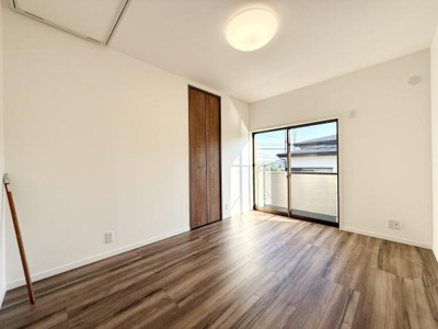 明るい光が差し込む洋室です。木目調の床が落ち着いた雰囲気を演出しています。収納に便利なクローゼット付きです。バルコニーへ直接出られる窓もポイントです。ゆとりのある空間設計となっています。