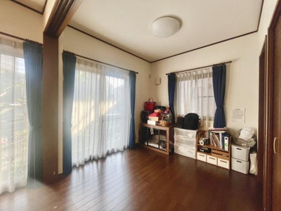 明るい光が差し込むリビングです。広い窓が開放感を演出しています。落ち着いた木目調の床が印象的です。