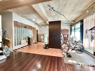 開放感のある天井とガラスブロックが特徴的なリビングです。床材の切り替えが空間のアクセントになっています。大きな窓からはたっぷりと光が入ります。自転車などの収納にも便利なスペースがあります。