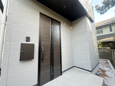 洗練されたデザインの玄関が住まいの印象を引き立てます。ゆとりのあるアプローチで使い勝手も良好です。シンプルな外観が建物全体をすっきり見せます。落ち着いた色調が周囲と調和しています。