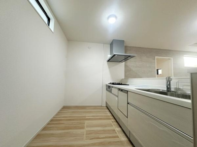 シンプルなデザインで清潔感のあるキッチンです。窓からの採光が明るい空間を演出しています。使いやすい配置で日々の調理をサポートします。収納も充実しており整理整頓しやすい仕様です。