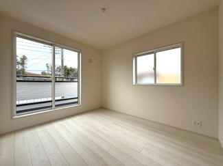 大きな窓があるため日差しがしっかりと入る洋室です。壁や床の色合いが落ち着いており室内がすっきりとした印象です。家具の配置もしやすいシンプルなレイアウトです。