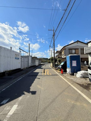 前面道路はゆるやかなカーブが特徴的で車通りの様子もしっかりと確認できます。明るい空の下周辺環境も開放的です。整備された舗装道路が続き現地の雰囲気を直接感じられます。