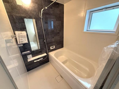 窓付きで換気がしやすく清潔感のあるバスルームです。大きな鏡とシャワーも備わっています。浴槽も広々としています。