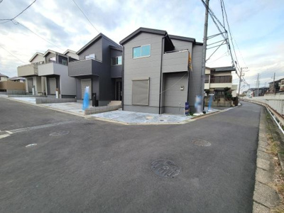 前面道路が広く車の出し入れがしやすい環境です。現地写真からは周囲に新しい住宅が建ち並んでいる様子が確認できます。角地に位置しているため開放感があります。