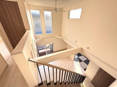 吹き抜けのデザインが開放感を演出しています。上部の窓から自然光がたっぷり差し込みます。室内全体が明るく空間にゆとりを感じられます。階段部分の手すりもシンプルで洗練されています。