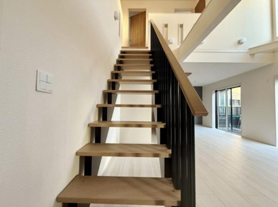 階段部分はシンプルなデザインで仕上げられており空間に溶け込んだ印象です。開放感のあるリビングに自然光が差し込み明るい室内です。手すりや床材の素材感がアクセントとなっています。