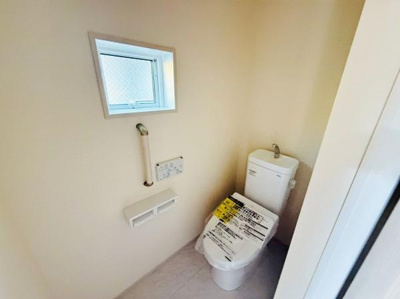 窓が設けられており換気しやすいトイレです。手すり付きでサポートもしっかりしています。清潔感のある明るい空間となっています。収納スペースも備わっています。使いやすい仕様が整っています。