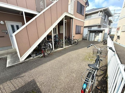 自転車を複数台置くことができるスペースがあります。建物の外観が整っており共用部も見通しが良いです。周囲に塀があり敷地内のスペースが区切られています。各住戸の玄関も分かりやすい位置にあります。