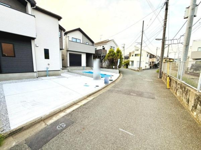 前面道路は幅員が広く車の出し入れがしやすい環境です。道路沿いには電柱があり周囲も静かな住宅街が広がっています。駐車スペースも確保されており生活利便性が感じられる立地です。