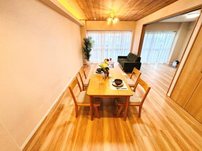 広々としたリビングが木目調の床と天井で統一感のある空間を作り出しています。大きな窓から自然光がしっかり入るため開放感があります。