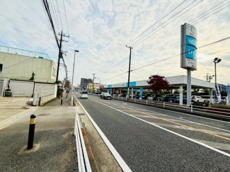 視界が開けた前面道路に面しており周辺には店舗や施設が見受けられます。道路幅もしっかり確保されており車や歩行者の通行も安心です。歩道も整備されていて日常の移動に便利な印象を受けます。