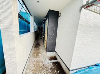 建物外観のデザインが現代的で印象的です。ドアや壁のカラーコントラストが目を引きます。外壁の質感がアクセントになっています。直線的な通路がすっきりとしたイメージを演出します。