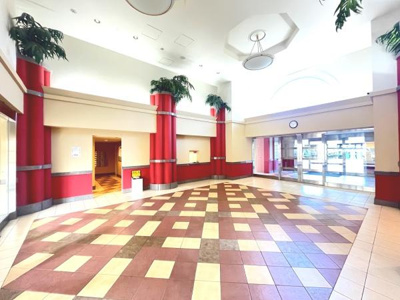 広々としたエントランスが印象的です。開放感のある造りで明るい光が差し込みます。植物が空間にアクセントを加えています。タイルの配色が特徴的でモダンな雰囲気を演出します。